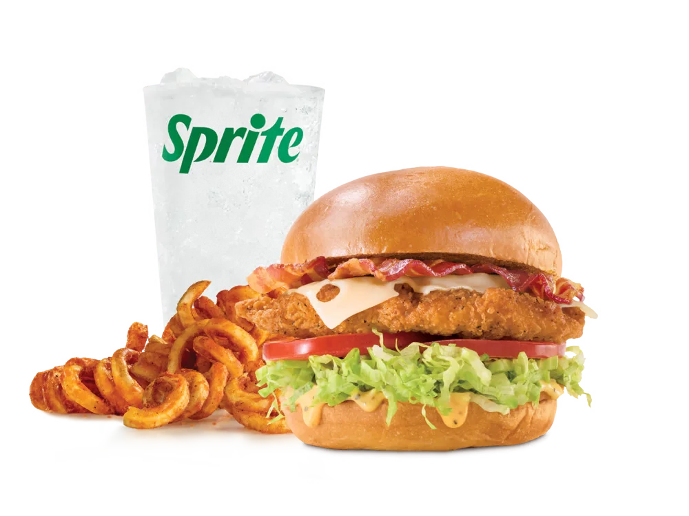 Arby's Chicken Bacon & Swiss Sandwich with crispy chicken, bacon, Swiss cheese, lettuce, tomato, and honey mustard on a toasted bun, served with medium curly fries and a medium soft drink.