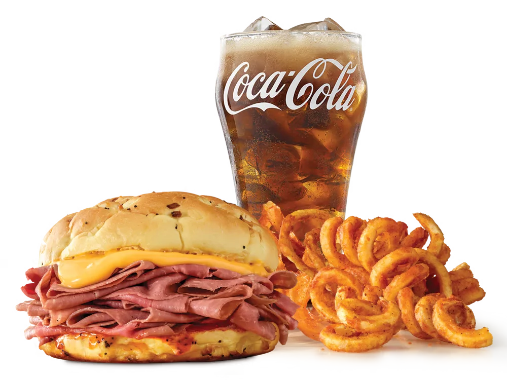 Arby's Classic Beef 'n Cheddar Sandwich with thinly sliced roast beef, cheddar cheese sauce, and Red Ranch sauce on a toasted onion roll, served with medium curly fries and a medium soft drink.