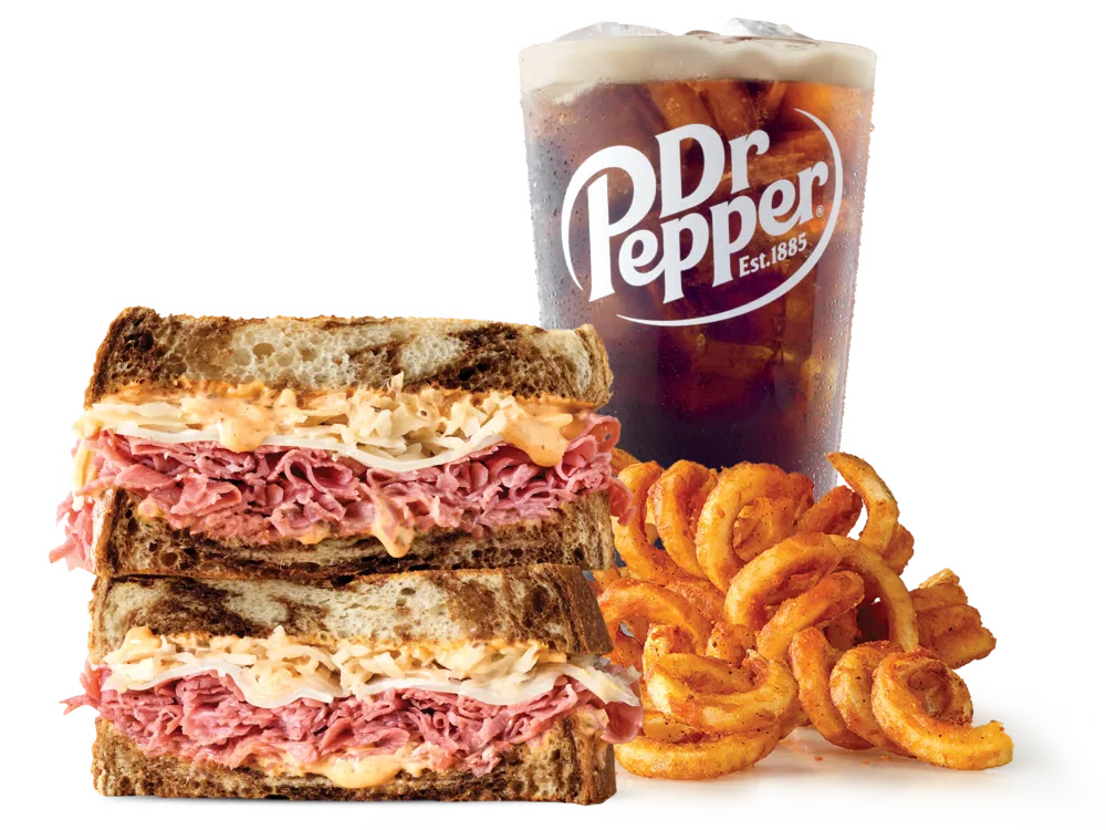 Arby's Corned Beef Reuben Sandwich with corned beef, Swiss cheese, sauerkraut, and Thousand Island dressing on marbled rye bread, served with medium curly fries and a medium soft drink.