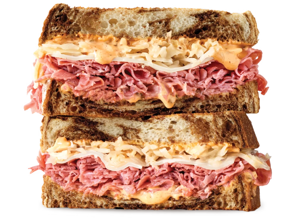 Arby's Corned Beef Reuben Sandwich with corned beef, Swiss cheese, sauerkraut, and Thousand Island dressing on marbled rye bread.