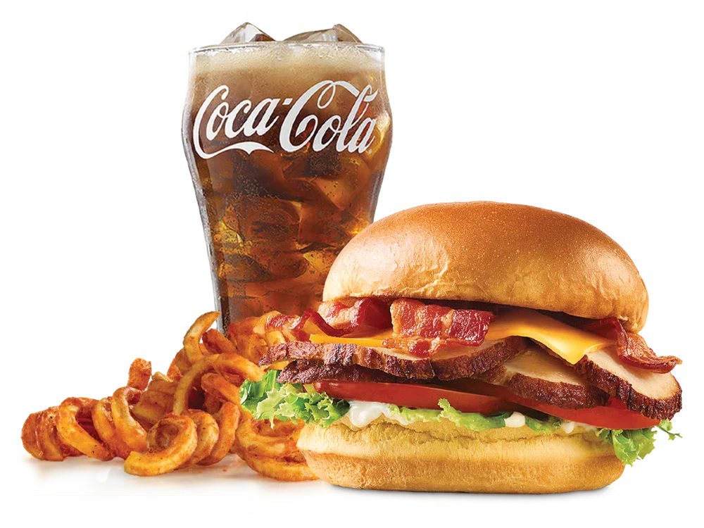 Arby's Deep Fried Turkey Club Sandwich with bacon, cheddar cheese, lettuce, tomato, and mayonnaise on a toasted brioche bun, served with curly fries and a drink.