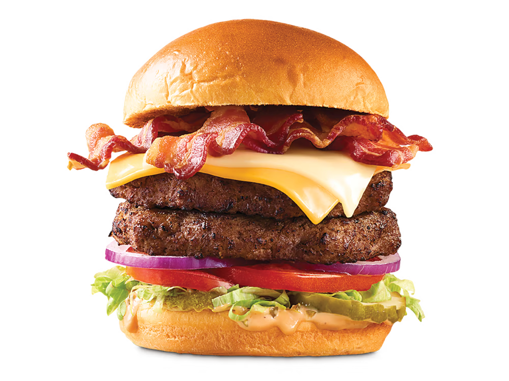 Arby's Double Big Cheesy Bacon Burger featuring two beef patties, bacon, American and Swiss cheeses, lettuce, tomato, onions, pickles, and burger sauce on a toasted brioche bun.