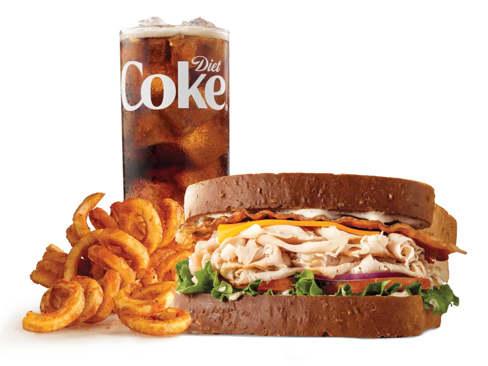 Arby's Roast Turkey Ranch & Bacon Sandwich with roast turkey, bacon, cheddar cheese, lettuce, tomato, red onion, and Parmesan Peppercorn Ranch sauce on honey wheat bread, served with medium curly fries and a medium soft drink.